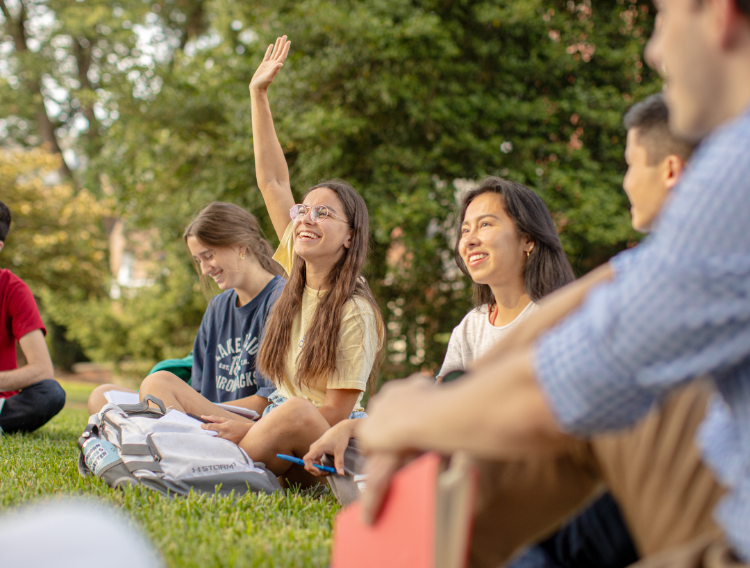 Students sitting outside on the grass. Students sitting outside on the grass.